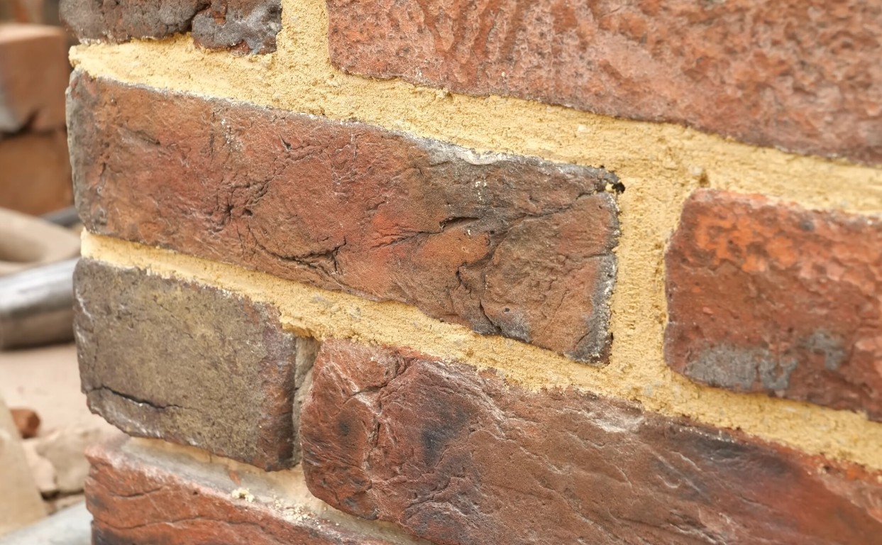 Close-up of tuckpointing and repointing mortar repair work on brick wall